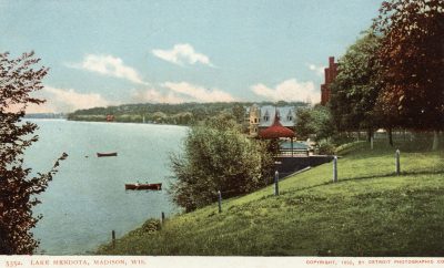 Colorized postcard featuring an illustration of Lake Mendota, the boat house, and the "Red Gym."