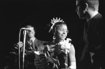 Carolyn Williams smiles with a crown on her head and a bouqet of flowers in her arms after being announced as the 1969 Homecoming Queen.