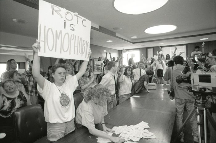 Students at a press conference protesting against homophobia in ROTC. Student holding a sign that reads “ROTC is Homophobic.”