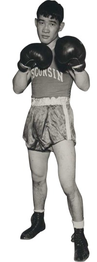 Akio Konoshima standing with fists up in boxing gloves with the team boxing uniform.