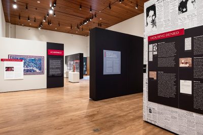 Display walls entitled “Housing Denied” and “Students Fight Housing Discrimination” and their accompanying text and artifacts in the Sifting & Reckoning exhibition.
